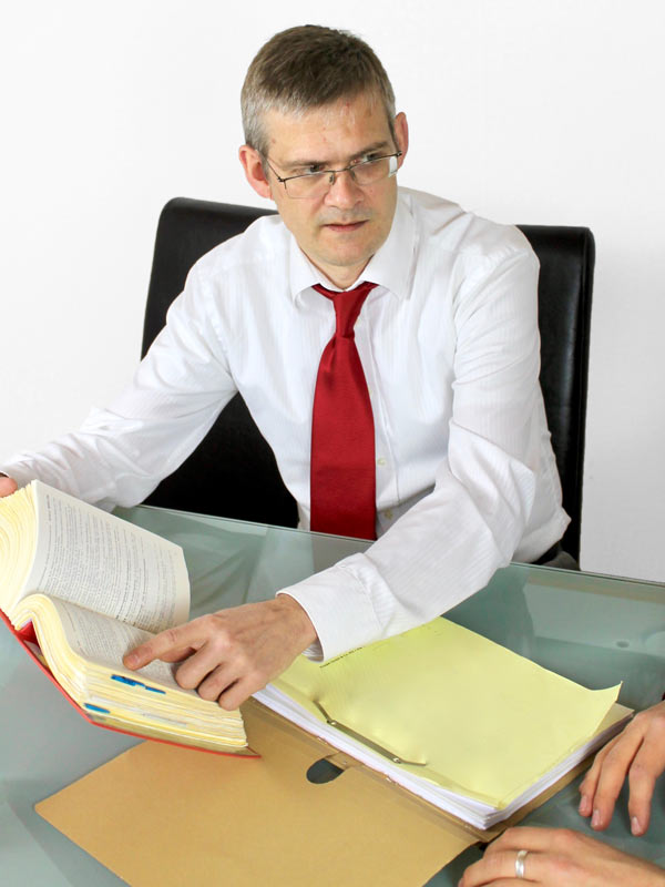 Rechtsanwalt Alexander Drescher am Schreibtisch mit Klienten